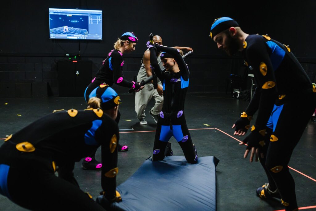 four students engage in a fight scene wearing mocap suits