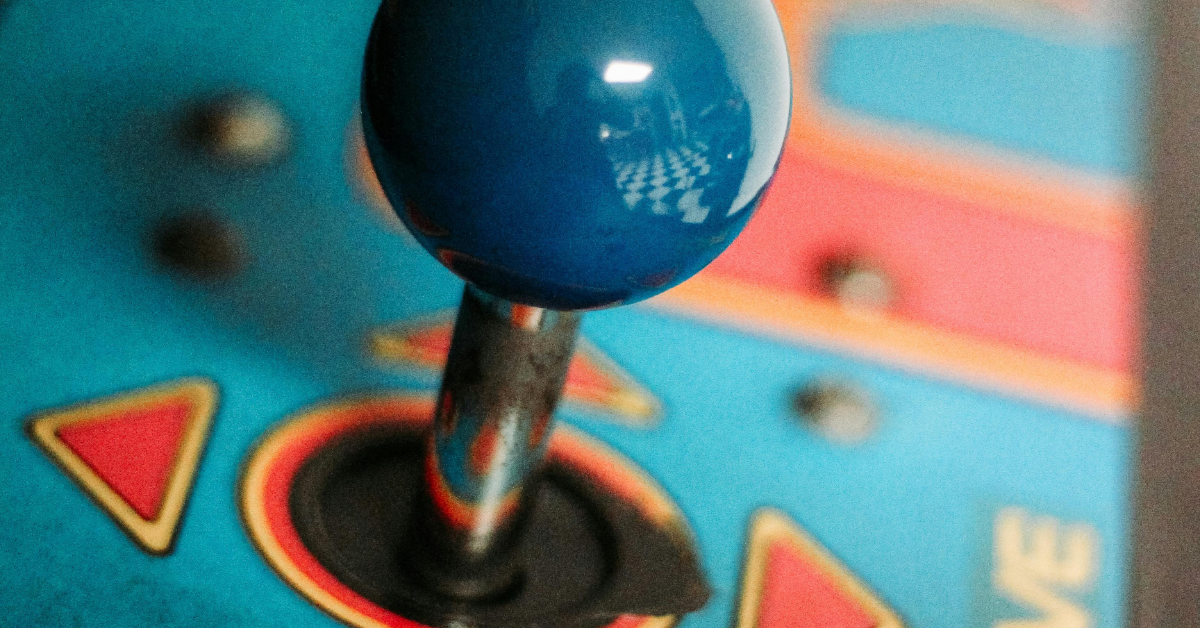 Joystick on retro video game arcade machine. Blue sphere on metal lever.