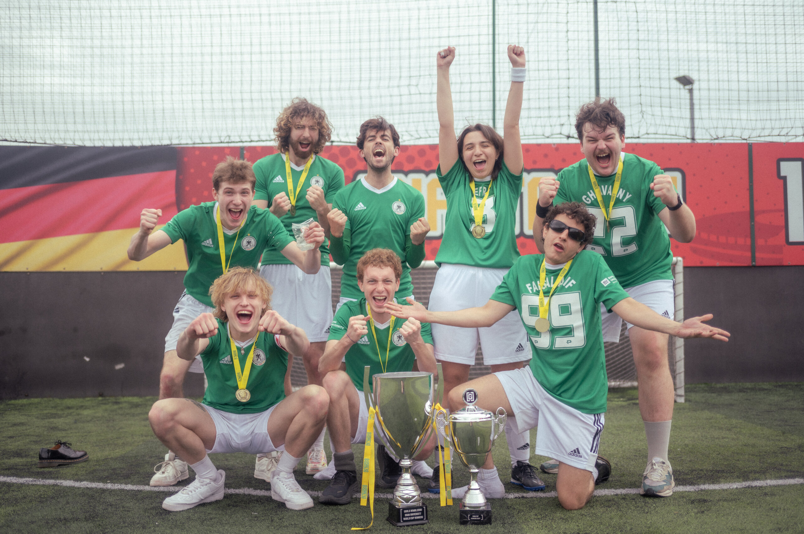 Group photo of the winning BIMM World Cup team from BIMM University Berlin. The team are in celebratory poses and their two trophies are in view.