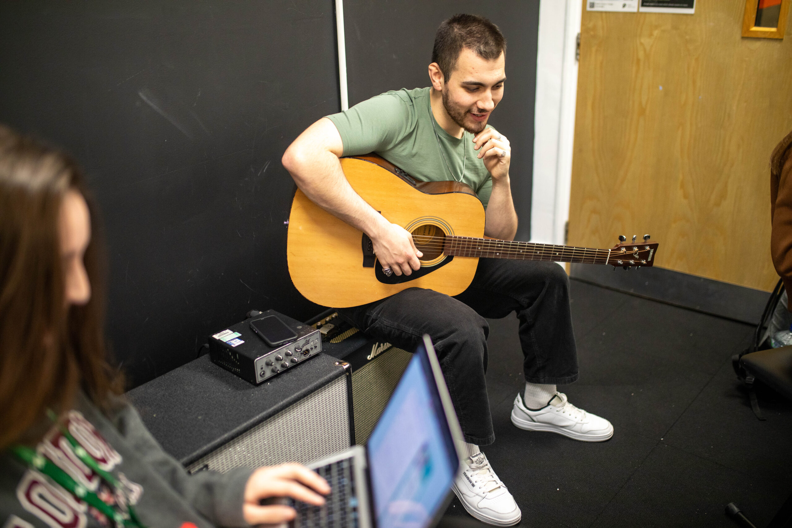 MA in popular music practice student sitting with guitar
