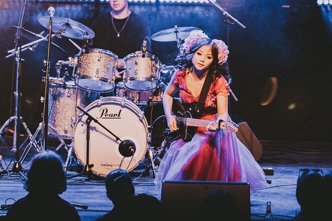Female guitarist on stage performing